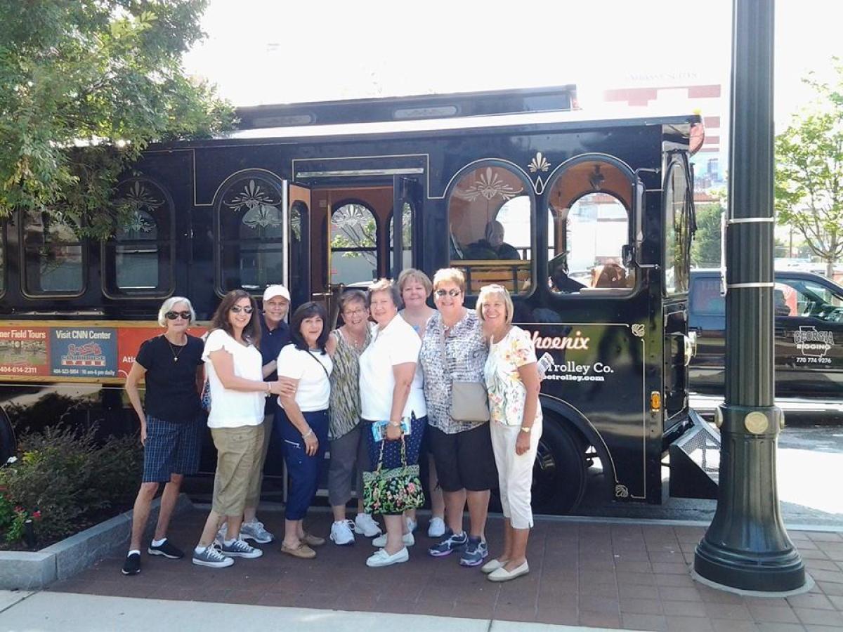 a group of people standing in front of a bus