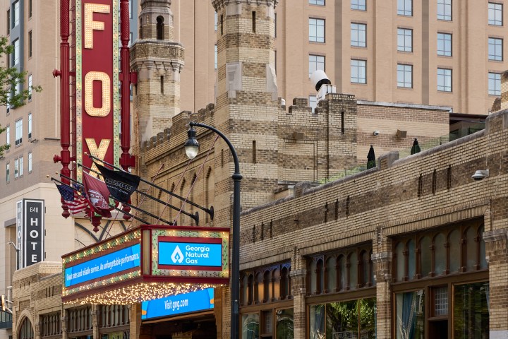Fox Theatre with red marquee and ornate brick facade on a city street.