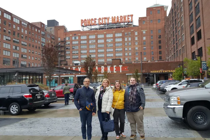 a group of people walking down a street next to a car