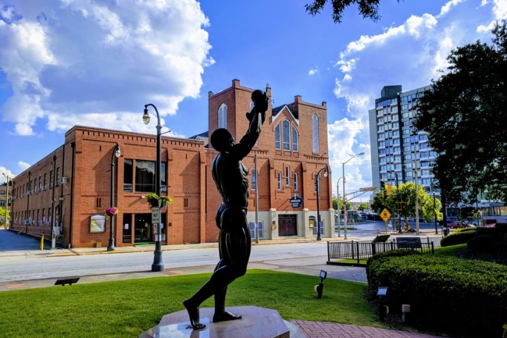 a large brick building with grass and trees