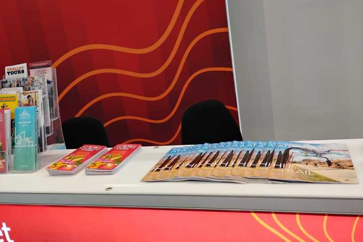 Brochures and flyers on a red counter with wavy line design.