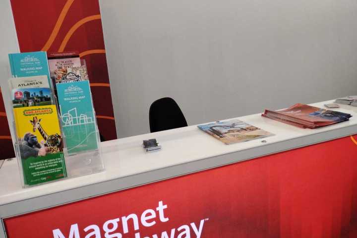 Conference booth with pamphlets on a red counter.