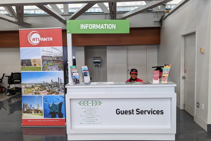 Information desk with guest services sign and an Atlanta banner on the side.