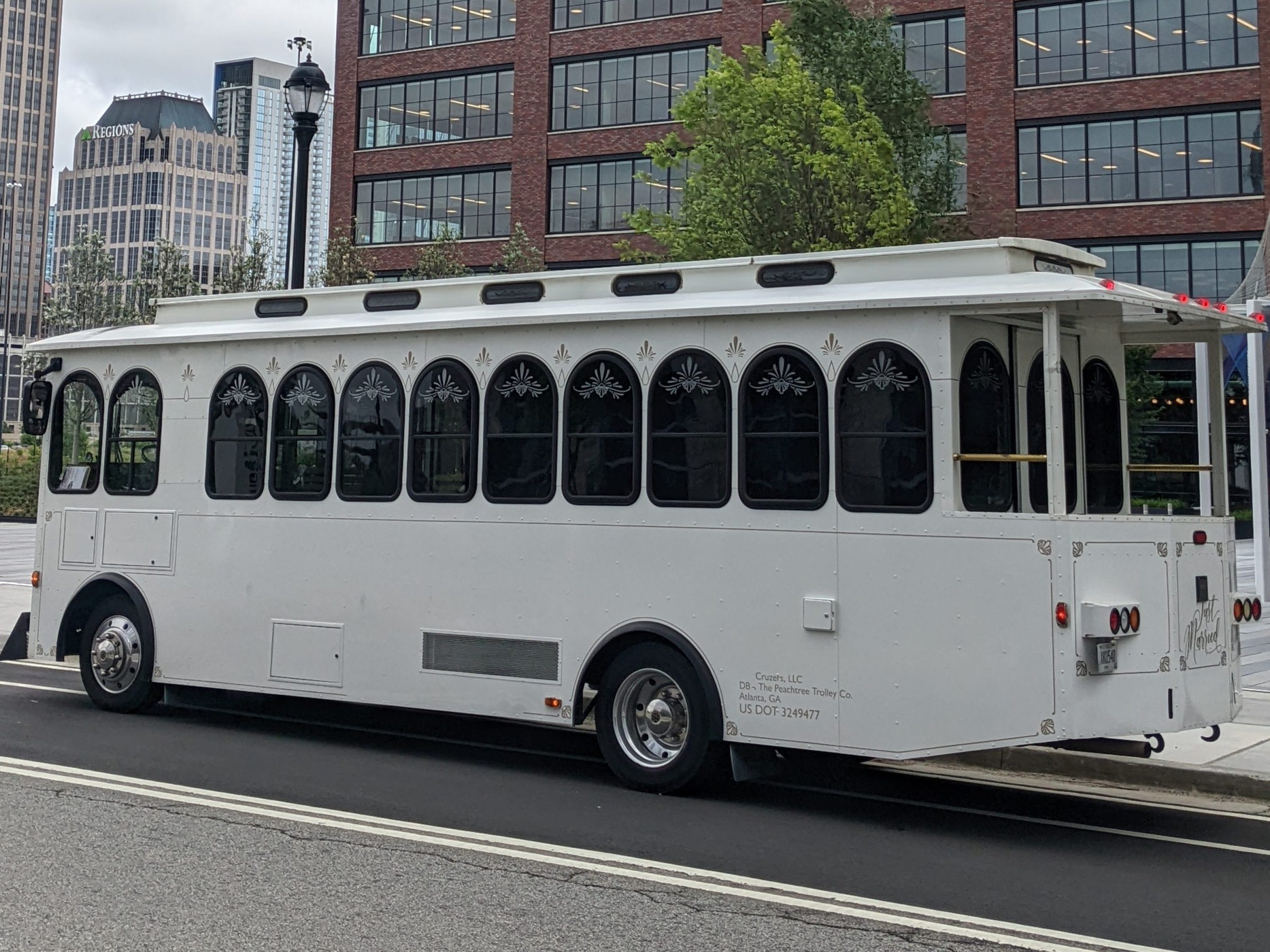 White trolley parked in front of a Microsoft office building on a cloudy day.